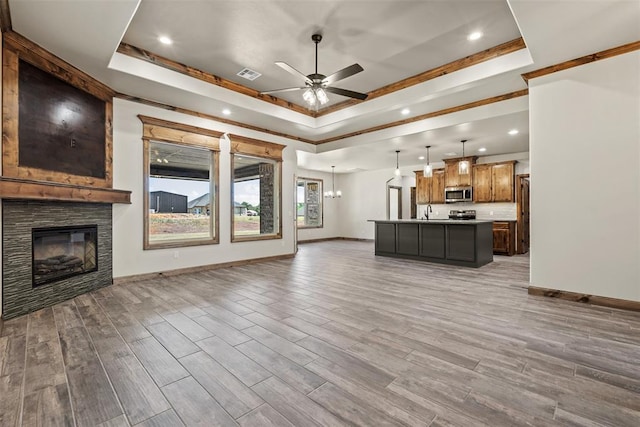 2414 Black Jack Way, Blanchard, OK 73010 - unfurnished living room featuring a raised ceiling, ceiling fan, recessed lighting, baseboards, and a fireplace