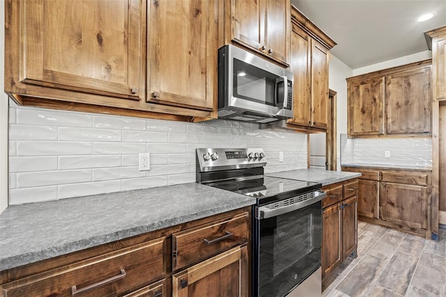 2414 Black Jack Way, Blanchard, OK 73010 - kitchen featuring stainless steel appliances, decorative backsplash, and light wood-style floors