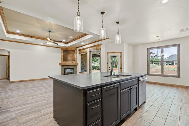 2414 Black Jack Way, Blanchard, OK 73010 - kitchen featuring a sink, a raised ceiling, baseboards, dishwasher, and a large fireplace
