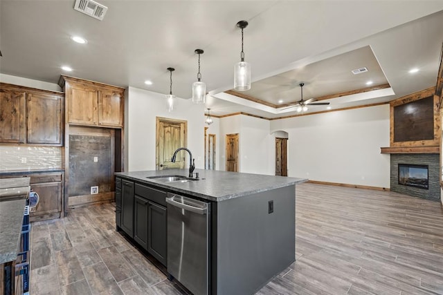 2414 Black Jack Way, Blanchard, OK 73010 - kitchen with a sink, dishwasher, a ceiling fan, a tray ceiling, and a stone fireplace