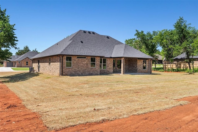 2414 Black Jack Way, Blanchard, OK 73010 - back of property featuring a yard, roof with shingles, brick siding, and central air condition unit