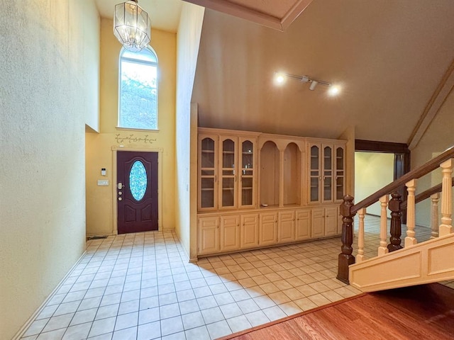 2010 Saddleback Blvd, Norman, OK 73072 - foyer entrance featuring stairs, light tile patterned floors, high vaulted ceiling, a textured wall, and a chandelier