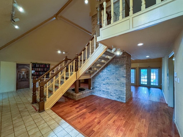 2010 Saddleback Blvd, Norman, OK 73072 - stairway with french doors, wood finished floors, high vaulted ceiling, and brick wall