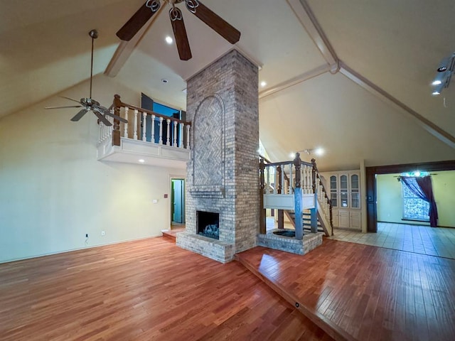 2010 Saddleback Blvd, Norman, OK 73072 - unfurnished living room with ceiling fan, high vaulted ceiling, beam ceiling, wood finished floors, and a fireplace