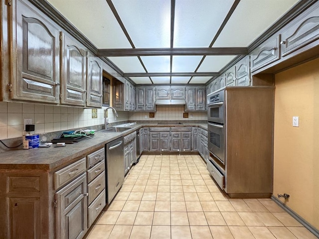 2010 Saddleback Blvd, Norman, OK 73072 - kitchen with stainless steel appliances, dark countertops, decorative backsplash, and light tile patterned flooring