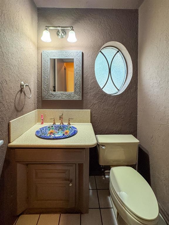 2010 Saddleback Blvd, Norman, OK 73072 - half bathroom with tile patterned flooring, a textured wall, and vanity