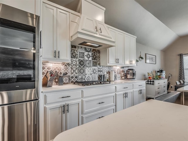 16112 Buffalo Dr, Oklahoma City, OK 73170 - kitchen featuring fridge, light countertops, decorative backsplash, custom exhaust hood, and white cabinetry