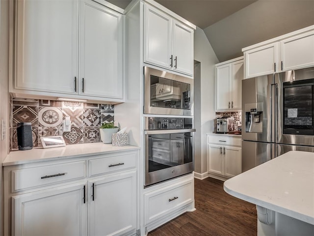 16112 Buffalo Dr, Oklahoma City, OK 73170 - kitchen with stainless steel appliances, white cabinetry, tasteful backsplash, vaulted ceiling, and dark wood-style floors