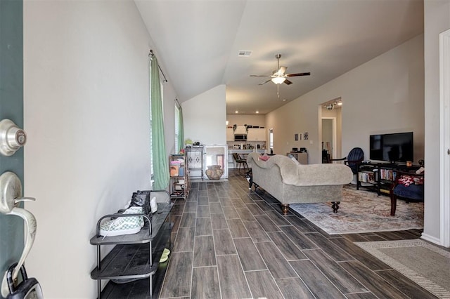 1301 Harvest Trl, Yukon, OK 73099 - living area with vaulted ceiling, a ceiling fan, and dark wood-style flooring