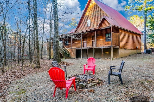 26 Huckleberry Trl, Broken Bow, OK 74728 - rear view of property featuring an outdoor fire pit, stairway, metal roof, a wooden deck, and log veneer siding
