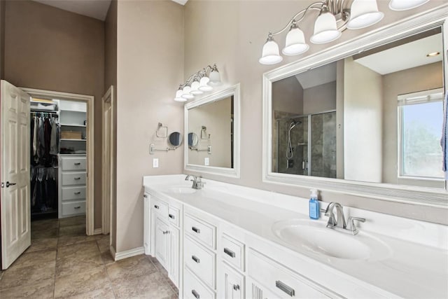 1329 S Southersby Dr, Mustang, OK 73064 - bathroom with a shower stall, double vanity, a walk in closet, and baseboards