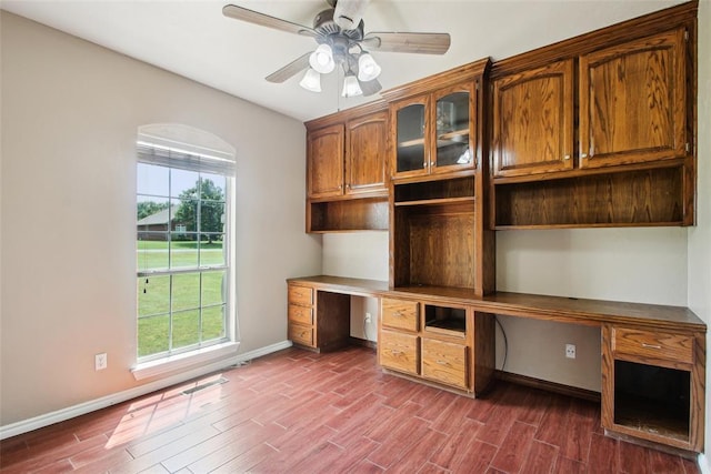 1329 S Southersby Dr, Mustang, OK 73064 - unfurnished office featuring built in desk, dark wood-style flooring, plenty of natural light, and a ceiling fan
