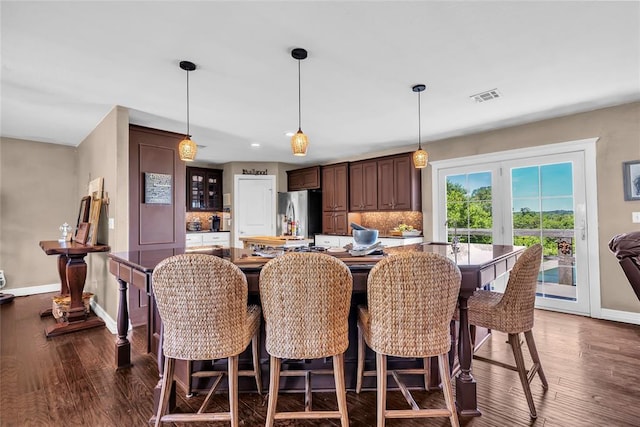 68 Ridgeview Rd, Ardmore, OK 73401 - kitchen featuring freestanding refrigerator, baseboards, dark wood-style flooring, a breakfast bar, and recessed lighting