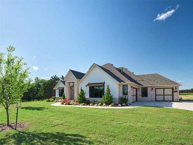 9117 SW 90th St, Mustang, OK 73064 - view of front of house featuring a garage, driveway, a front lawn, stone siding, and stucco siding