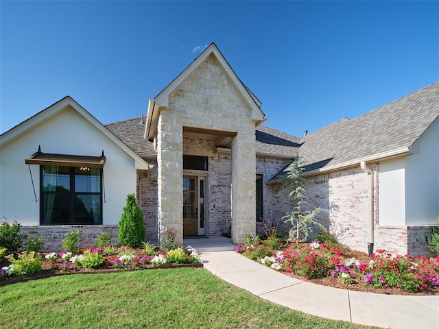 9117 SW 90th St, Mustang, OK 73064 - view of front of home with a shingled roof, stucco siding, a front yard, and stone siding