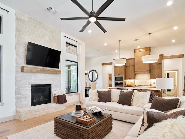 9117 SW 90th St, Mustang, OK 73064 - living room featuring light wood-type flooring, ceiling fan, a fireplace, baseboards, and recessed lighting
