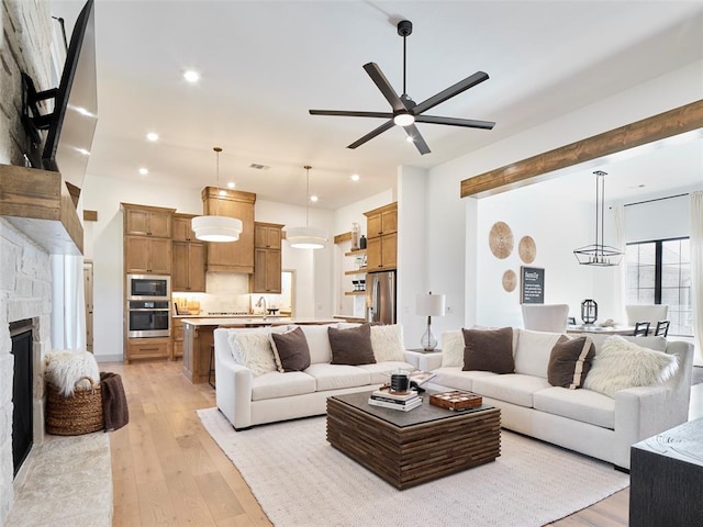 9117 SW 90th St, Mustang, OK 73064 - living room with light wood finished floors, a ceiling fan, a fireplace, and recessed lighting