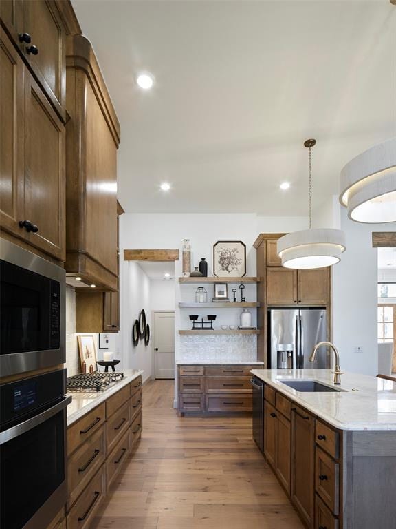 9117 SW 90th St, Mustang, OK 73064 - kitchen with appliances with stainless steel finishes, open shelves, backsplash, a sink, and wood finished floors
