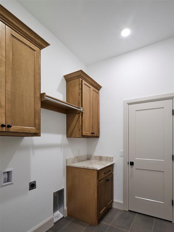 9117 SW 90th St, Mustang, OK 73064 - washroom featuring hookup for an electric dryer, cabinet space, washer hookup, dark tile patterned floors, and recessed lighting