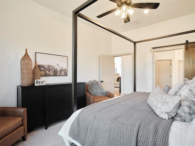 9117 SW 90th St, Mustang, OK 73064 - bedroom featuring a barn door, light carpet, and a ceiling fan