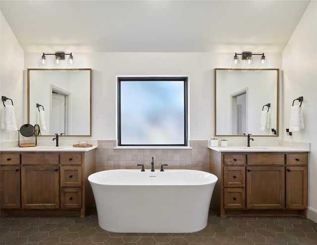 9117 SW 90th St, Mustang, OK 73064 - full bath featuring tile patterned flooring, a soaking tub, two vanities, tile walls, and a wainscoted wall