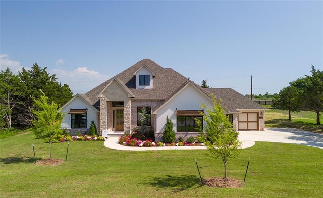 9117 SW 90th St, Mustang, OK 73064 - view of front of home with stone siding, concrete driveway, a front lawn, and an attached garage