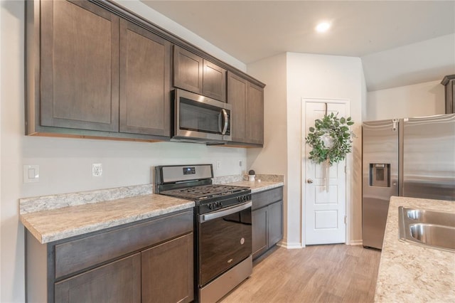 3429 Molly Dr, Yukon, OK 73099 - kitchen with appliances with stainless steel finishes, light wood finished floors, dark brown cabinets, and light countertops