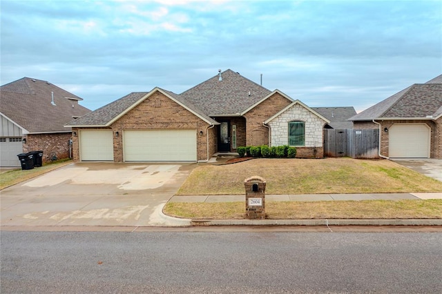 2604 NE 16th St, Moore, OK 73160 - view of front of property featuring a garage, driveway, brick siding, and a shingled roof