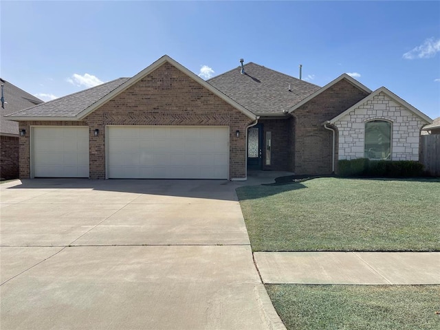 2604 NE 16th St, Moore, OK 73160 - view of front of home with a garage, driveway, roof with shingles, a front yard, and brick siding