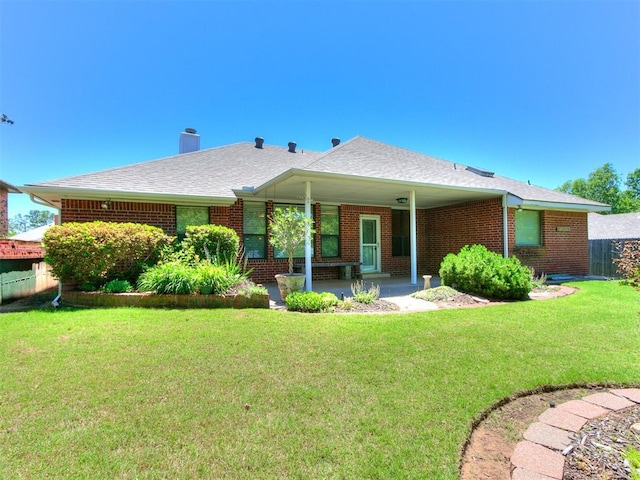 2601 Northwood Ln, Edmond, OK 73013 - back of property featuring brick siding, a chimney, a patio area, and a shingled roof