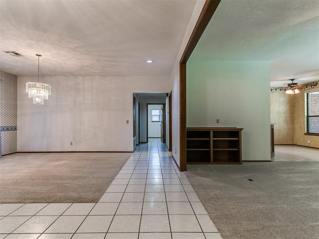 2601 Northwood Ln, Edmond, OK 73013 - spare room featuring light colored carpet, light tile patterned flooring, a chandelier, baseboards, and a textured ceiling