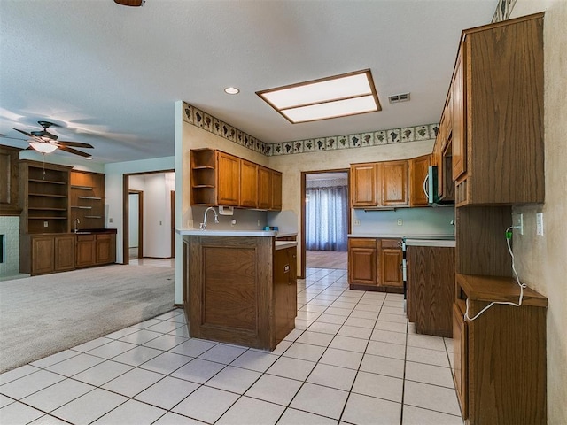 2601 Northwood Ln, Edmond, OK 73013 - kitchen with open shelves, brown cabinetry, light colored carpet, open floor plan, and a ceiling fan