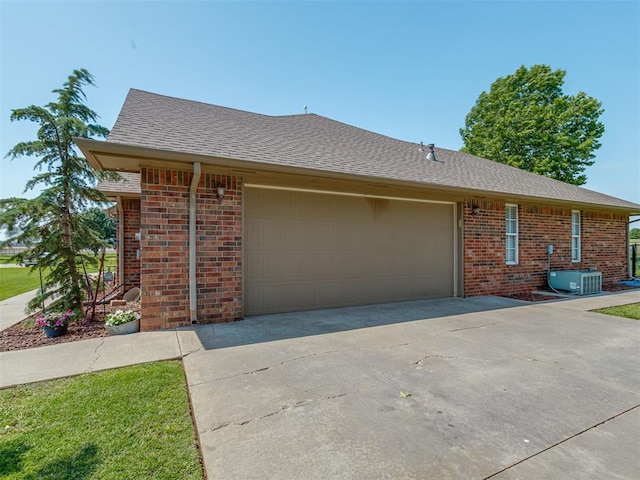 846 County St Unit 2910, Tuttle, OK 73089 - view of property exterior with brick siding, a garage, concrete driveway, and central AC unit