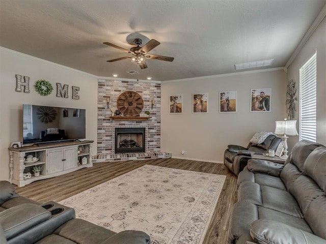 846 County St Unit 2910, Tuttle, OK 73089 - living room with ceiling fan, wood finished floors, crown molding, baseboards, and a brick fireplace