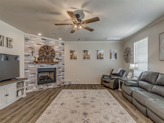 846 County St Unit 2910, Tuttle, OK 73089 - living area with a ceiling fan, crown molding, wood finished floors, a fireplace, and a textured ceiling