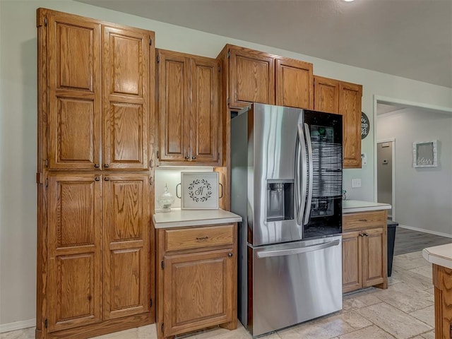 846 County St Unit 2910, Tuttle, OK 73089 - kitchen featuring stainless steel fridge, brown cabinetry, light countertops, and baseboards