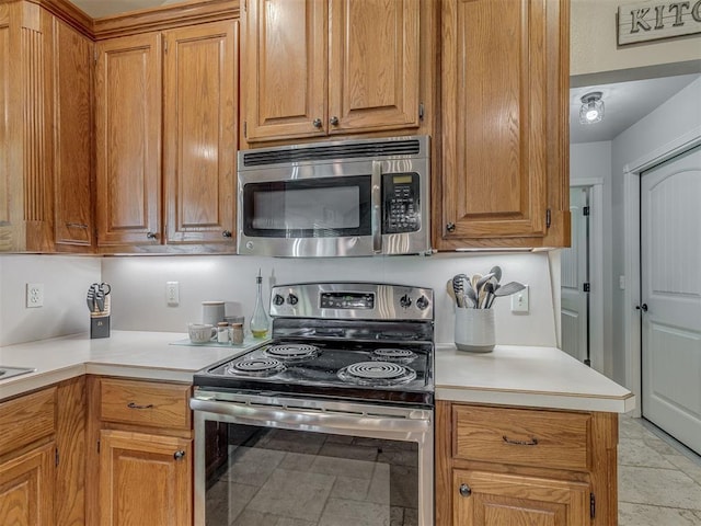 846 County St Unit 2910, Tuttle, OK 73089 - kitchen with stainless steel appliances, light countertops, and brown cabinetry