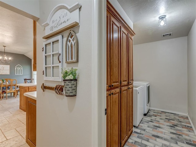 846 County St Unit 2910, Tuttle, OK 73089 - laundry room featuring washing machine and clothes dryer, a chandelier, cabinet space, a textured ceiling, and baseboards