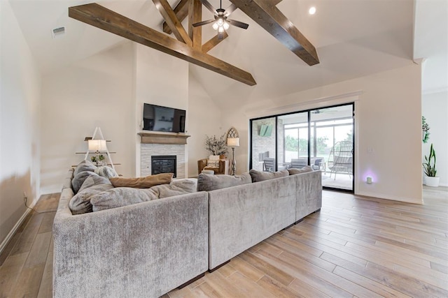 5804 NW 159th St, Edmond, OK 73013 - living area with beamed ceiling, a stone fireplace, light wood-type flooring, baseboards, and high vaulted ceiling