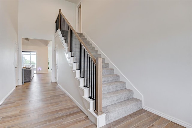 5804 NW 159th St, Edmond, OK 73013 - staircase featuring wood finished floors, baseboards, and a high ceiling