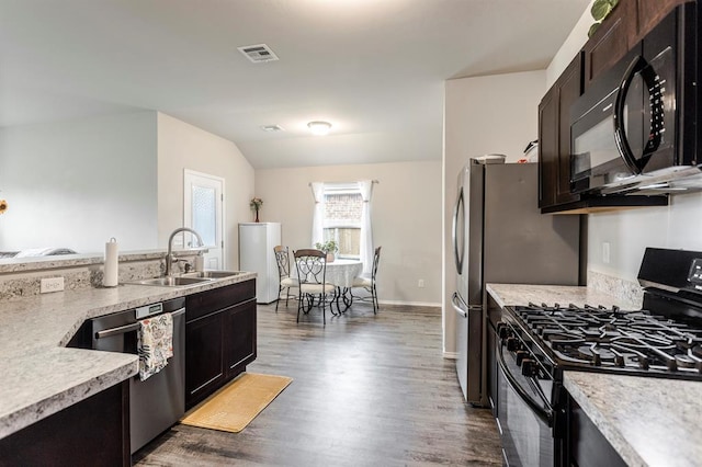 5318 Kye Dr, Tuttle, OK 73089 - kitchen with black appliances, a sink, light countertops, wood finished floors, and vaulted ceiling