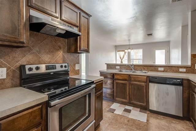 9520 SW 24th Ter, Oklahoma City, OK 73128 - kitchen featuring appliances with stainless steel finishes, under cabinet range hood, a sink, a chandelier, and tasteful backsplash