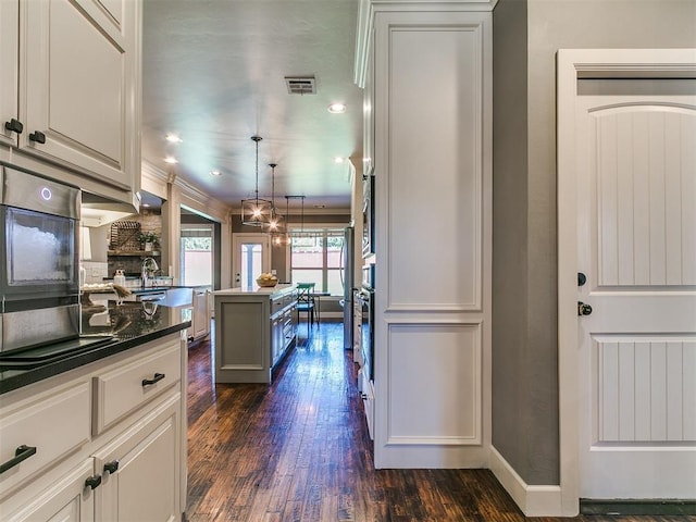14210 Jack Rabbit Trl, Arcadia, OK 73007 - kitchen with dark wood-style flooring, a center island, dark countertops, hanging light fixtures, and recessed lighting