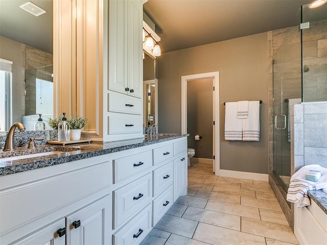 14210 Jack Rabbit Trl, Arcadia, OK 73007 - full bath with double vanity, a stall shower, toilet, baseboards, and tile patterned flooring