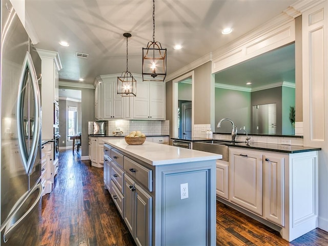 14210 Jack Rabbit Trl, Arcadia, OK 73007 - kitchen featuring appliances with stainless steel finishes, a sink, a kitchen island, dark wood finished floors, and decorative backsplash