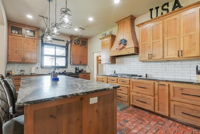 9027 Ns 3500th Rd, Prague, OK 74864 - kitchen featuring premium range hood, brick floors, a breakfast bar area, a center island, and tasteful backsplash