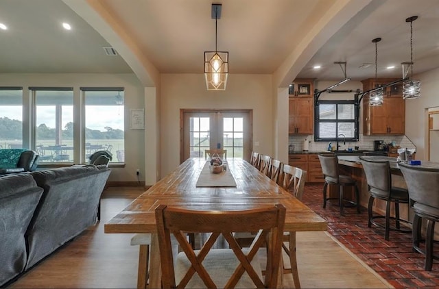 9027 Ns 3500th Rd, Prague, OK 74864 - dining space featuring french doors, recessed lighting, wood finished floors, and arched walkways