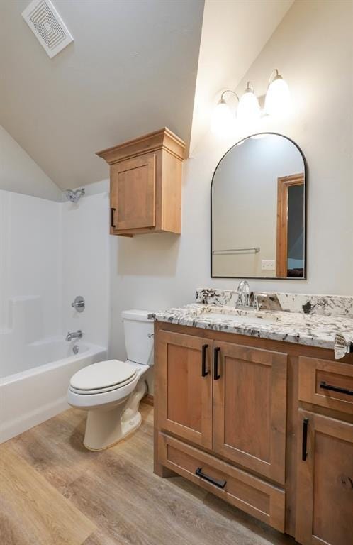 9027 Ns 3500th Rd, Prague, OK 74864 - full bathroom with vaulted ceiling, vanity, toilet, wood finished floors, and shower / washtub combination