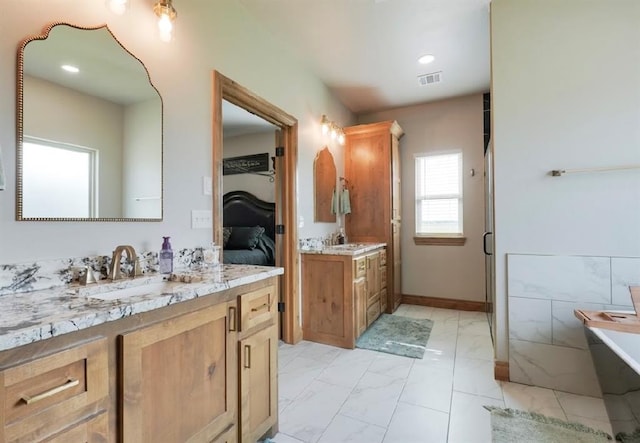 9027 Ns 3500th Rd, Prague, OK 74864 - bathroom featuring ensuite bath, marble finish flooring, two vanities, a soaking tub, and recessed lighting