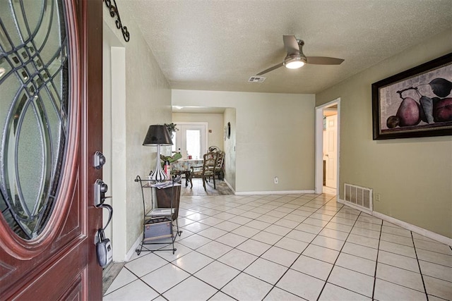 3117 Lazy Ln, Del City, OK 73115 - foyer entrance featuring a textured ceiling, light tile patterned flooring, baseboards, and a ceiling fan